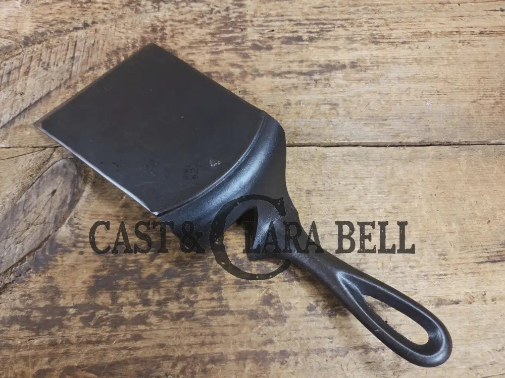 Custom made one of a kind early #7 1900βs Lodge no notch repurposed spatula. Turned an ordinary cracked skillet into a