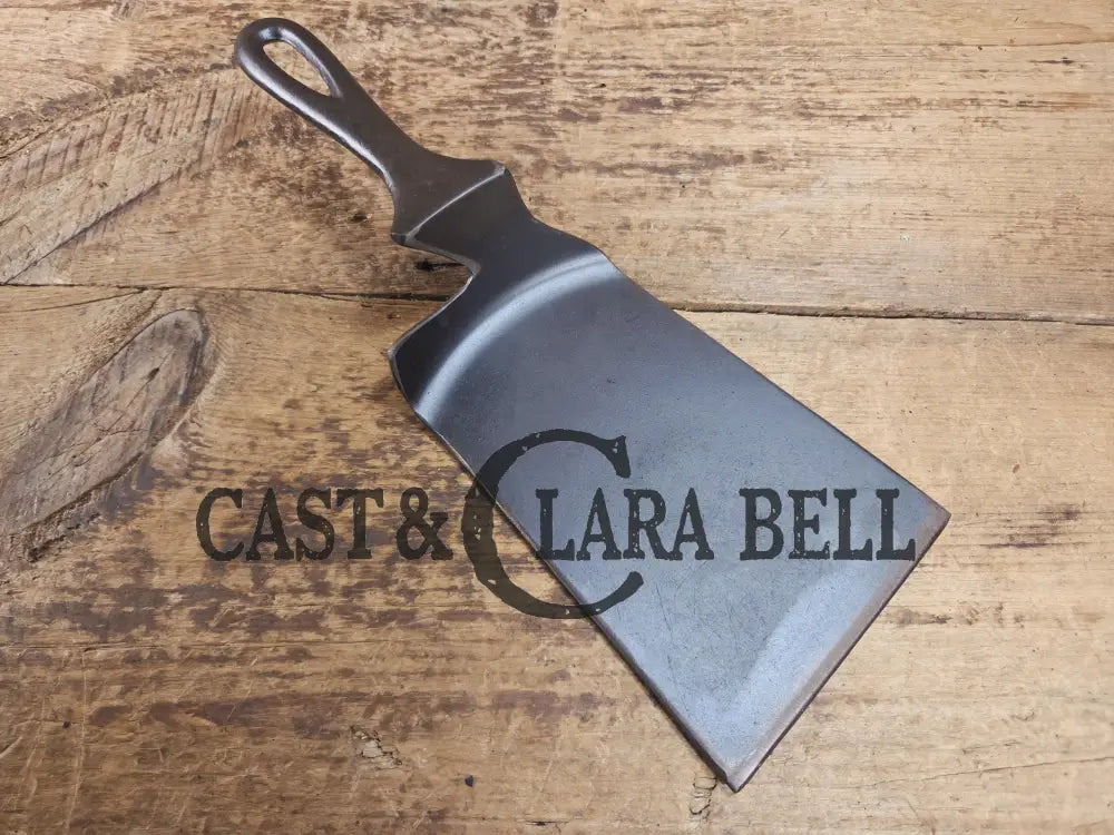 Custom made one of a kind early #7 1900βs Lodge no notch repurposed spatula. Turned an ordinary cracked skillet into a