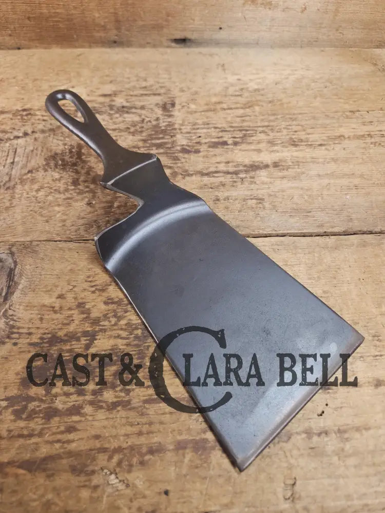 Custom made one of a kind early #7 1900βs Lodge no notch repurposed spatula. Turned an ordinary cracked skillet into a
