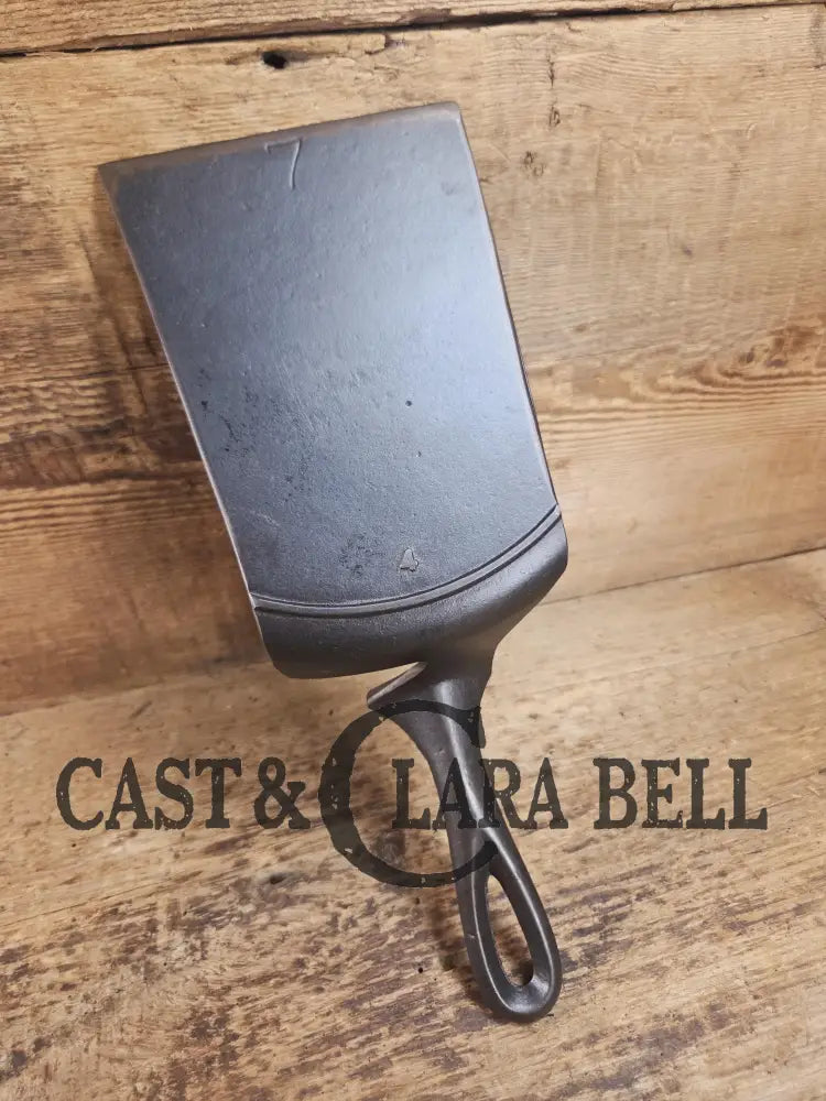 Custom made one of a kind early #7 1900βs Lodge no notch repurposed spatula. Turned an ordinary cracked skillet into a