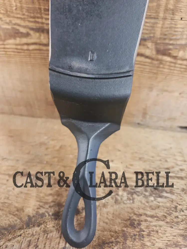 Custom made one of a kind early #9 1900βs Lodge repurposed spatula. Turned an ordinary cracked skillet into a grill