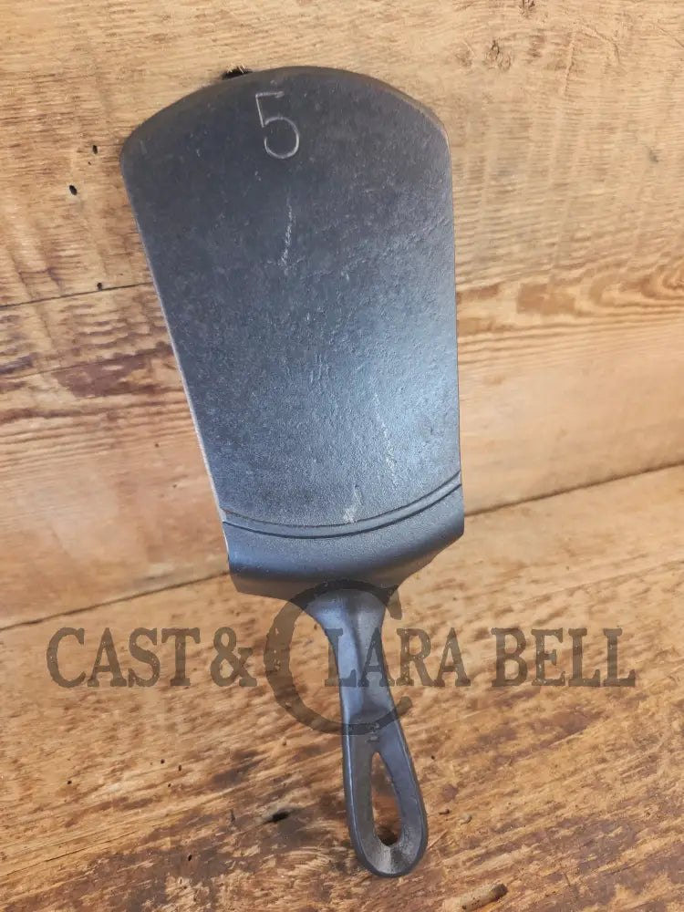 Custom made #5 Lodge Cast Iron Skillet Spatula w RAISED B. Reclaimed from a early to mid 1900’s single notch Lodge
