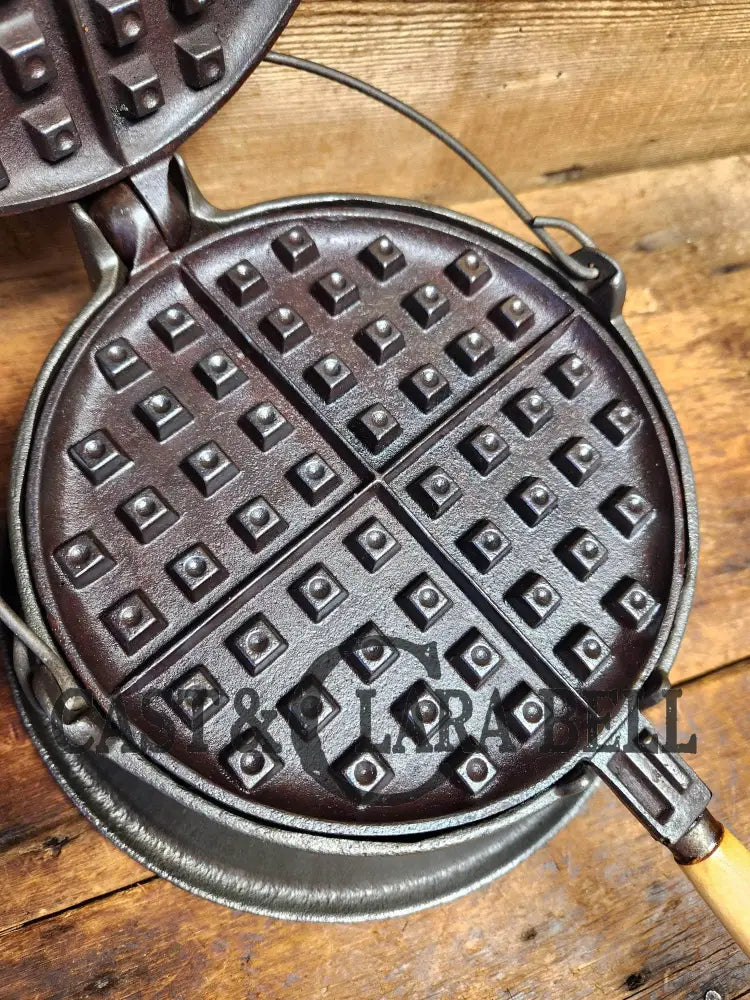 https://castandclarabell.com/cdn/shop/files/early-1900s-wagner-mfg-co-1892-no-8-waffle-iron-with-rare-tall-base-new-oak-handles-301.webp?v=1699765116&width=1445